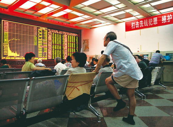 Chinese investors monitor stock prices at the Zhong Xin securities stock trading house in Beijing, China, Friday, Aug. 5, 2011. Asian stock markets tumbled Friday amid fears the U.S. may be heading back into recession and Europe's debt crisis is worsening. (AP Photo/Andy Wong)