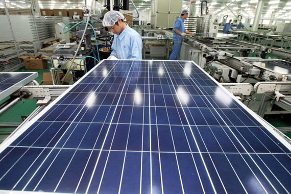 FILE - In this Nov. 18, 2011 file photo released by China's Xinhua News Agency, Chinese work on the production line at a solar panel factory of the Eoplly New Energy Technology Co., Ltd. in Nantong City, east China's Jiangsu Province. The Obama administration moved Thursday, May 17, 2012 to impose stiff new tariffs on solar panels made in China, finding that Chinese companies are improperly flooding the U.S. market with government-subsidized products. (AP Photo/Xinhua, Xu Congjun, File) NO SALES