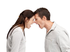 Portrait of an angry couple shouting each other head to head against white background