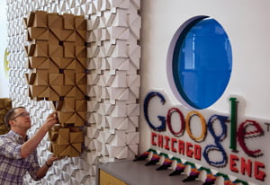 A Google employee uses Bloxes, interlocking cardboard building blocks, to form a geometric shape in his work space at Chicago Google headquarters, in Chicago, Tuesday, March 20, 2012. Republican presidential candidate, former Massachusetts Gov. Mitt Romney, toured the offices Tuesday and participated in live-streaming discussion during the visit. (AP Photo/Steven Senne)