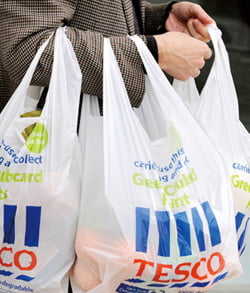  A shopper carries Tesco bags outside a branch of the supermarket, in west London on September 30, 2008. Tesco, Britain's top retailer, met forecasts with a 10 percent rise in first-half profit, signalling it can cope with weak markets even as it called for interest rate cuts and steps to steady banks.    REUTERS/Toby Melville (BRITAIN)/2008-09-30 20:58:29/

