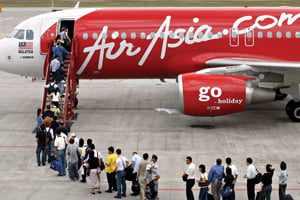 TO GO WITH STORY "Asia-airport-Singapore-Malaysia-terminal,sched"
Passengers wait in line on the tarmac to board an Air Asia Airbus A320 at the Low-Cost Carrier Terminal at the Kuala Lumpur International Airport in Sepang, 14 April 2006. The chairs are plastic, the facilities are few and some passengers are grumbling, but budget airlines are hailing new no-frills terminals in Singapore and Malaysia as a cost-saving success. In a spirit of not-so-friendly rivalry, the neighbouring nations launched their low-cost terminals last month in a race to completion which saw the doors flung open just a few days apart.   AFP PHOTO/TENGKU BAHAR



