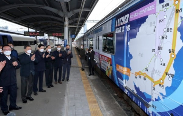 문재인 대통령이 25일 부산 부전역에서 열린 '동남권 메가시티 구축 전략 보고'에 참석, 부전역 플랫폼에서 열차에 랩핑 된 자료를 보며 울산광역시 송철호 시장으로부터'생활 행정공동체 전략 보고'를 듣고 있다. /사진=연합뉴스