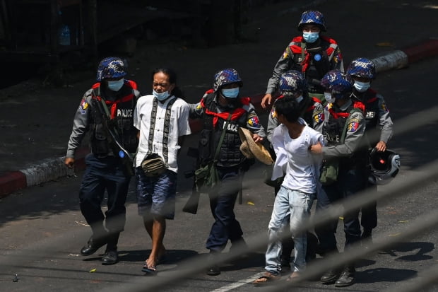  미얀마 최대 도시인 양곤에서 27일(현지시간) 진압경찰이 쿠데타 규탄 시위대를 체포하고 있다./ 사진=연합뉴스