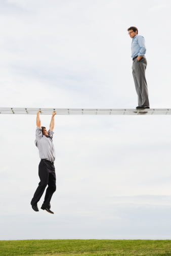 Businessman on horizontal ladder watching businessman suspended below