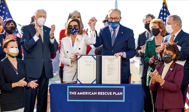 낸시 펠로시 미국 하원의장(앞줄 왼쪽 세 번째)과 찰스 슈머 상원 원내대표(네 번째)가 10일(현지시간) 하원의 경기부양책 가결 직후 워싱턴DC 의사당에서 만나 기념사진을 찍고 있다. 조 바이든 대통령이 12일 이 법안에 서명하면 효력이 발생한다.  /EPA연합뉴스 
