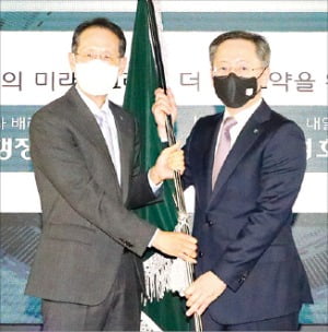 박성호 신임 하나은행장(오른쪽)이 25일 지성규 전임 행장으로부터 은행 깃발을 넘겨받고 있다.  /하나은행  제공 