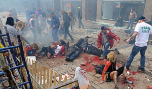 Injured people and debris lie on the sidewalk near the Boston Marathon finish line following an explosion in Boston, Monday, April 15, 2013. (AP Photo/MetroWest Daily News, Ken McGagh)  MANDATORY CREDIT