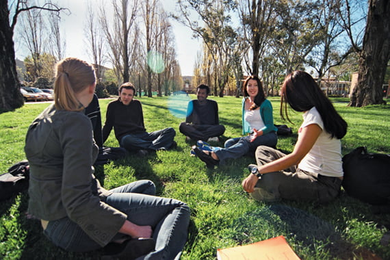 ANU students sitting under trees on