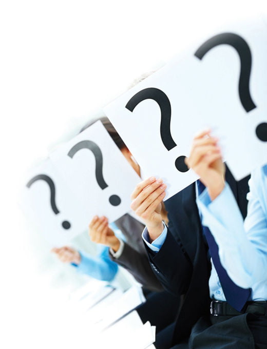 Business people holding question mark on boards in the conference room