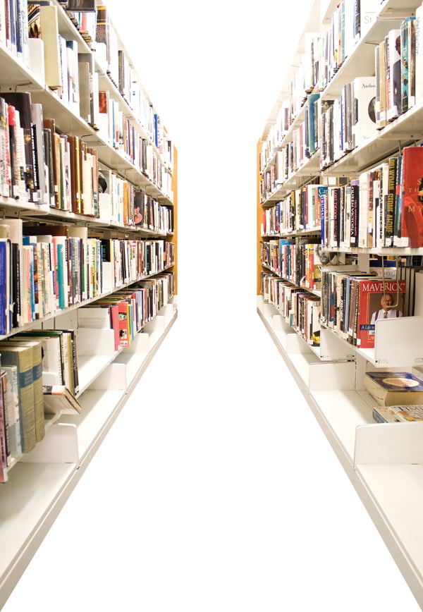 The aisles in a public library with shelves full of books - isolated over white.