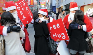 성탄절인 25일 서울 명동에서 산타클로스 옷을 입은 이들이 지나가는 시민들에게 '프리 허그'를 해주고 있다.

/강은구기자 egkang@hankyung.com 008.12.25   