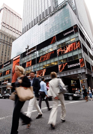People walk past the Lehman Brothers headquarters in New York September 16, 2008. Central banks pumped emergency funds into world financial markets for a second day on Tuesday in an increasingly fraught effort to contain the fallout from the crisis sweeping Wall Street's biggest firms. REUTERS/Chip East (UNITED STATES)/2008-09-16 23:46:48/