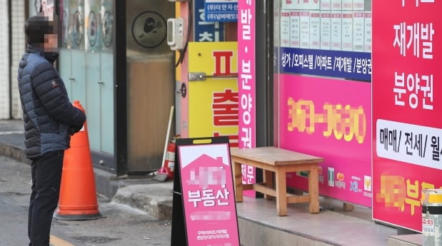 서울 서대문구의 한 중개업소 앞에서 한 시민이 인근 아파트들의 매매와 전월세 가격을 살펴보고 있다. /연합뉴스