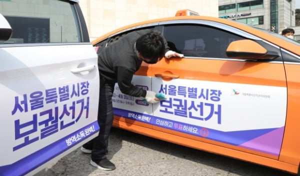 지난 3일 서울시선관위 관계자들이 성북구 대왕기업 택시차고지에서 서울시장 보궐선거 홍보물을 붙이고 있다. 선거는 다음달 7일이다 /사진=연합뉴스