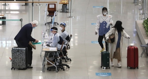 인천국제공항 제1터미널 입국장에서 해외입국자들이 방역관계자들로부터 안내를 받고 있다/사진=뉴스1