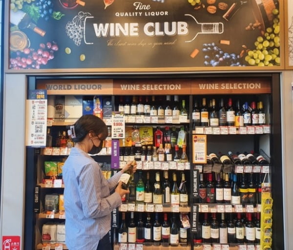 한 소비자가 이마트24 매장에서 와인을 고르고 있다. 이마트24 제공
