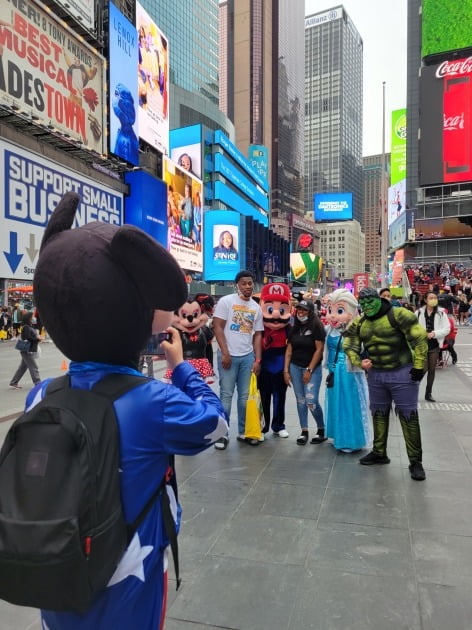 다양한 인형 캐릭터들이 24일(현지시간) 미국 뉴욕 타임스퀘어 앞에서 관광객들과 사진을 찍고 있다. 뉴욕=조재길 특파원

