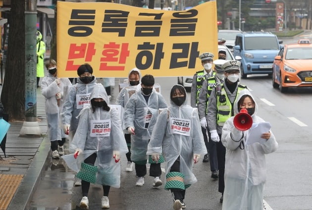 2021 등록금반환운동본부 관계자들이 지난달 서울 종로구 경복궁역 인근에서 코로나19 비대면 수업 여파로 인한 대학 등록금 반환을 촉구하는 삼보일배를 하고 있다.