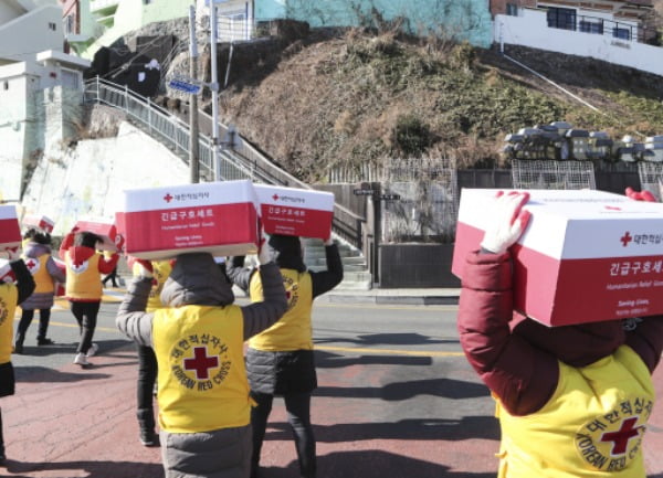 지난 2월 부산 서구 남부민동에서 적십자사 부산지사 봉사자들이 저소득가정에 전달할 구호품을 이고 지고 이동하고 있다. /사진=연합뉴스