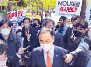 차정인 부산대 총장(가운데)이 19일 부산교대 본관 앞에서 부산교대 총동창회의 통합 MOU 반대 시위에 막혀  되돌아가고 있다.  연합뉴스 