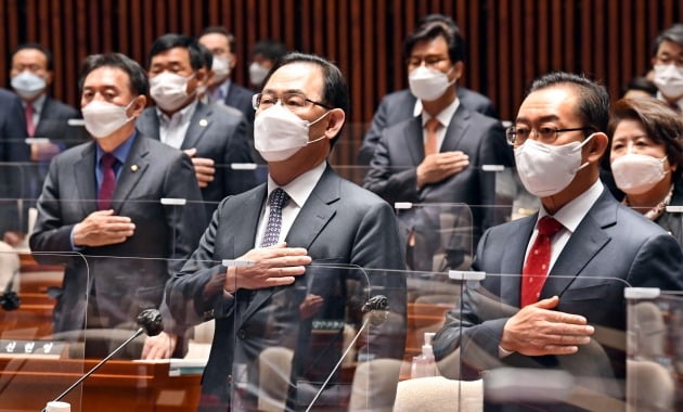 주호영 국민의힘 당 대표 권한대행 및 원내대표(앞줄 오른쪽 두 번째)와 의원들이 4월 16일 의원총회에서 국기에 대한 경례를 하고 있다. 의원총회에선 국민의당과의 합당 문제를 놓고 의원들 간 격론이 벌어졌다. 연합뉴스