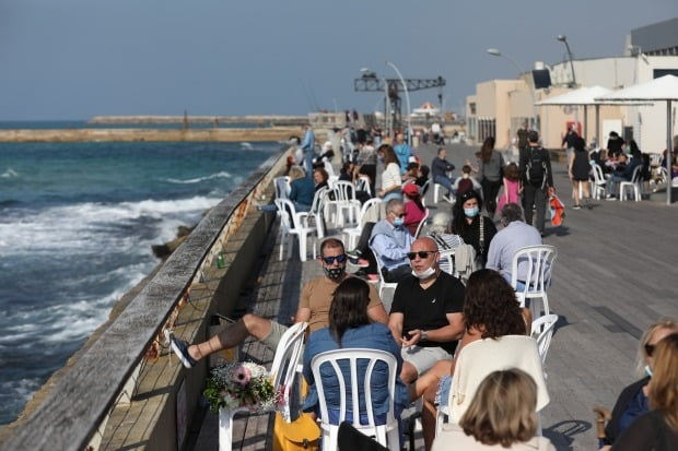 이스라엘 텔아비브 해변에 시민들이 모여들어 모처럼 화창한 날씨를 즐기고 있다/사진=EPA