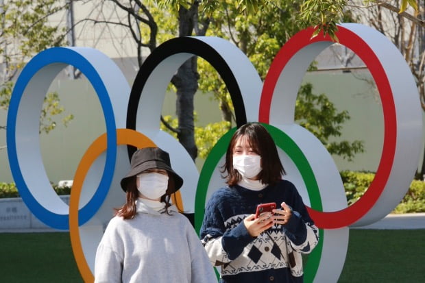 일본 도쿄에서 행인들이 오륜 조형물 앞을 지나가고 있다. 사진=AP