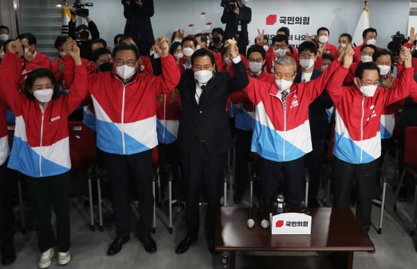 국민의힘 오세훈 서울시장 후보가 7일 서울 여의도 국민의힘 중앙당사 개표상황실에서 방송3사(KBS,MBC,SBS) 공동 출구 조사 결과발표에서 더불어민주당 박영선 서울시장 후보를 앞서는 걸로 예측되자 김종인 비대위원장 등과 함께 두손을 맞잡고 환호하고 있다. 사진=연합뉴스