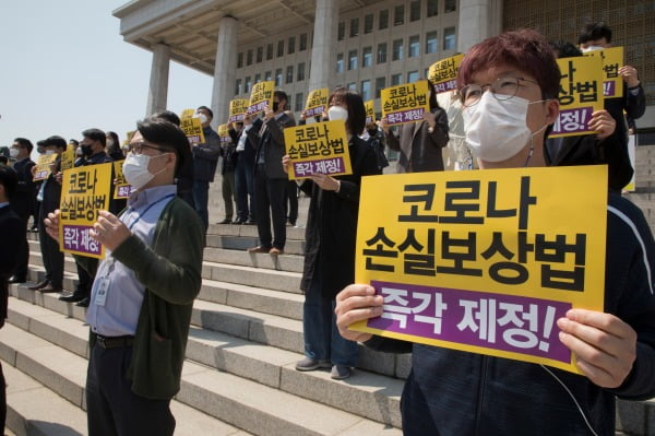 정의당 당원들이 지난 19일 국회의사당 앞 계단에서 열린 코로나 손실보상법 소급적용 제정 촉구 기자회견에서 피켓을 들고 있다. /사진=뉴스1