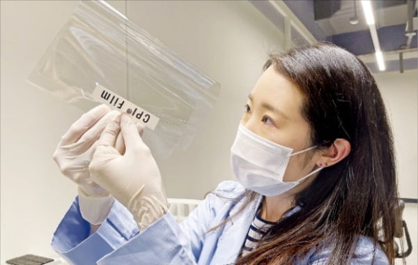 코오롱인더스트리 연구원이 샤오미 폴더블폰에 적용된 투명 폴리이미드 필름(CPI®)을 점검하고 있다. 코오롱 제공 