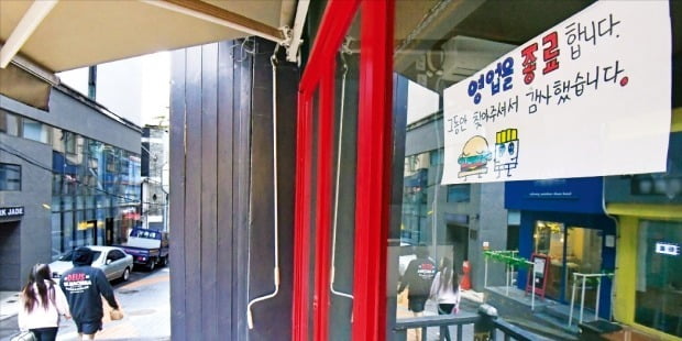 21일 오후 서울지하철 2호선 이대역 인근 상점들이 모인 골목. 불 꺼진 한 상점 앞에 ‘영업을 종료한다’는 안내문이 붙어있다. /김영우 기자 