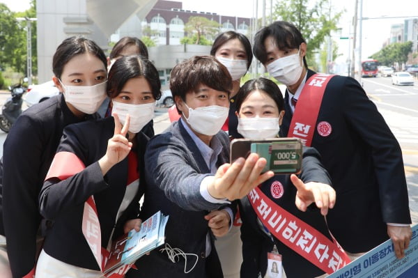 국민의힘 당 대표 출마를 선언한 이준석 전 최고위원이 24일 오후 대구 북구 경북대학교 북문 앞에서 대학생들과 인사 나누며 기념사진을 찍고 있다.사진=뉴스1