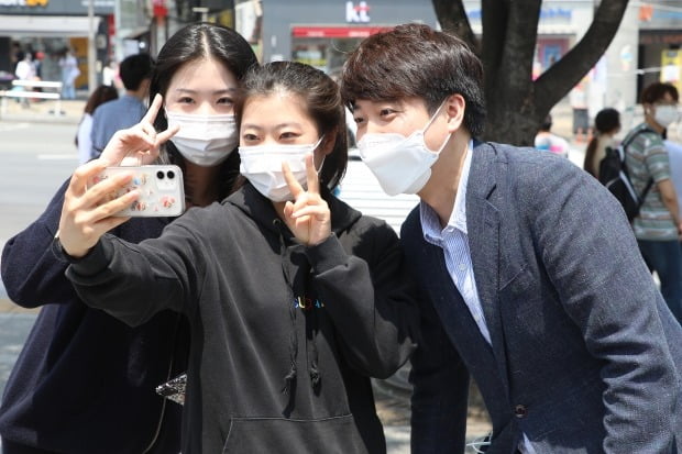 국민의힘 당 대표 출마를 선언한 이준석 전 최고위원이 24일 오후 대구 북구 경북대학교 북문 앞에서 대학생들과 인사 나누며 기념사진을 찍고 있다. 사진=뉴스1