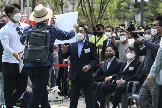 윤석열 전 검찰총장이 9일 오후 서울 남산예장공원 개장식에서 본인을 규탄하며 행사에 난입한 시민을 바라보고 있다. 연합뉴스