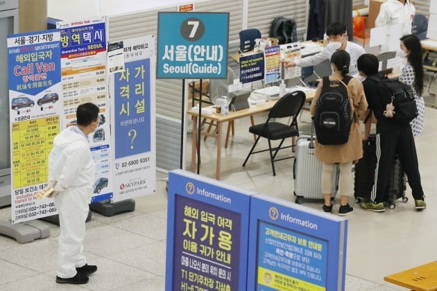 정부가 해외에서 예방접종을 완료한 사람을 대상으로 국내 입국시 2주간 자가격리 조치를 면제하는 입국관리체계 개편안을 실시한다. 지난 14일 오후 인천국체공항 제1여객터미을 통해 입국한 해외 여행객들이 해외입국자 전용버스 이용 안내를 받고 있다./ 뉴스1