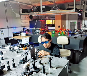 UNIST 물리학과 연구진이 특수현미경을 사용해 QLED TV 원천기술을 개발하고 있다.  UNIST 제공
 