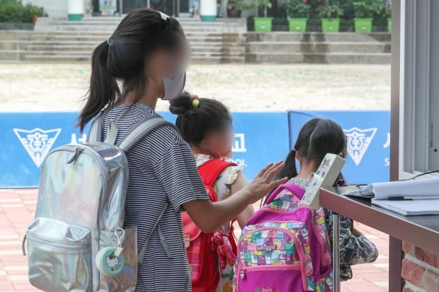  7일 오전 서울 시내의 한 초등학교에서 학생들이 등교를 하며 체온측정을 하고 있다. [사진=뉴스1]