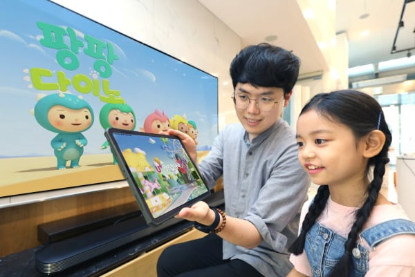 LG유플러스는 키즈콘텐츠 역량을 강화하기 위해 인기 애니메이션 ‘젤리고’를 제작한 드림팩토리스튜디오에 지분투자를 단행했다고 27일 밝혔다. 사진은 어린이 모델이 U+아이들나라와 ‘팡팡다이노’를 시청하고 있는 모습/사진제공=LG유플러스