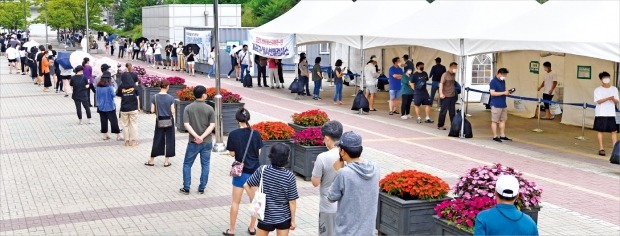 < 1km 긴 줄 > 코로나19 신규 확진자가 급증하면서 4차 대유행이 본격화하고 있다. 7일 서울 신수동 서강대역 환승주차장 인근에 마련된 임시선별검사소에 검사받으려는 시민들이 길게 줄을 서 있다.  /김범준 기자 