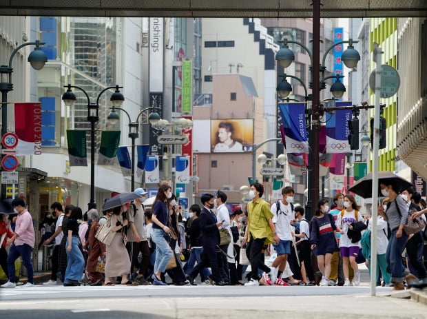 도쿄에서 행인들이 도쿄올림픽·패럴림픽 깃발로 장식된 거리를 걷고 있다. /사진=연합뉴스