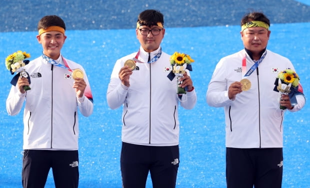 26일 일본 유메노시마 공원 양궁장에서 열린 도쿄올림픽 남자 단체전 시상식에서 한국 김제덕(왼쪽부터), 김우진, 오진혁이 금메달을 목에 걸고 기념촬영을 하고 있다/사진=연합뉴스