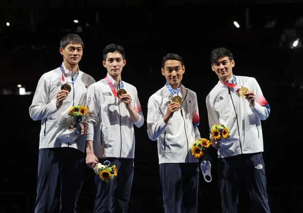  28일 일본 지바의 마쿠하리 메세에서 열린 도쿄올림픽 남자 펜싱 사브르 단체전 이탈리아와의 경기에서 금메달을 획득한 대한민국 선수들이 시상대에서 금메달을 들어 보이고 있다. 사진=연합뉴스