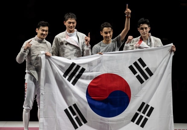 28일 일본 지바의 마쿠하리 메세에서 열린 도쿄올림픽 남자 펜싱 사브르 단체전 대한민국 대 이탈리아 결승전. 대한민국의 승리로 경기가 끝나자 선수들이 태극기를 펼친 채 기념촬영을 하고 있다. 사진=연합뉴스