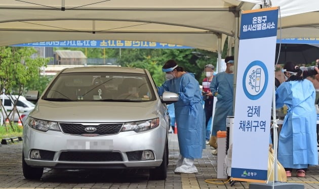 코로나19 신규 확진자수가 네자릿수를 지속적으로 기록하고 있는 가운데 2일 서울 은평구 서울혁신파크에 설치된 승차검사(드라이브스루) 임시선별검사소에서 의료진들이 검체를 채취하고 있다. 서울의 현재 드라이브스루 선별검사소는 서초구에 2개소 은평구의 1개소를 포함해 총3곳이다/사진=한경DB