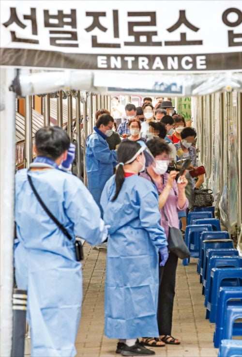 코로나19 하루 신규 확진자 수가 처음으로 2000명을 넘겼다. 11일 오전 서울 관악구보건소에서 코로나19 검사를 받으려는 시민들이 줄지어 차례를 기다리고 있다.   /연합뉴스 
