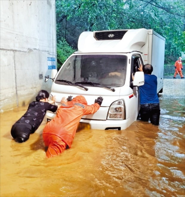 [포토] 고립차량 밀어올리는 구조대원 