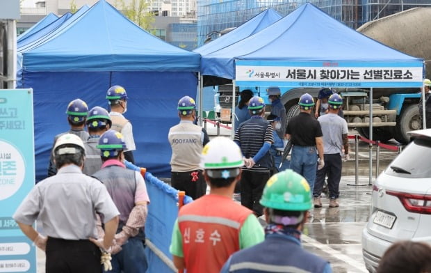 24일 서울 강동구 한 아파트 공사현장에 설치된 선별진료소에서 근로자들이 검사를 받고 있다. /사진=연합뉴스