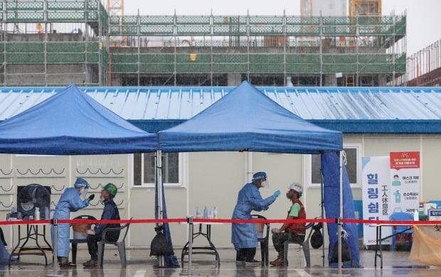 서울 강동구 한 아파트 공사현장에 설치된 선별진료소에서 근로자들이 검사를 받고 있다. 사진=연합뉴스.