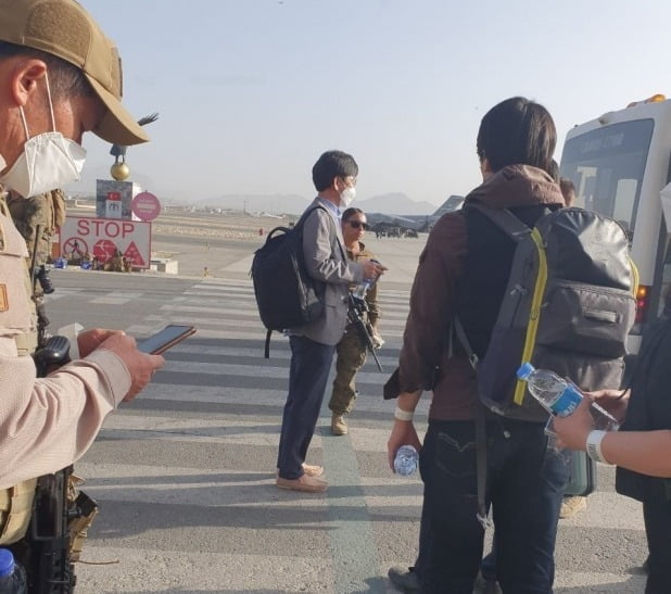 김일응 주아프가니스탄 대사관 공사참사관이 카불공항에서 한국으로 이송될 아프간인 수송 지원을 지휘하고 있는 모습. 사진=외교부 제공